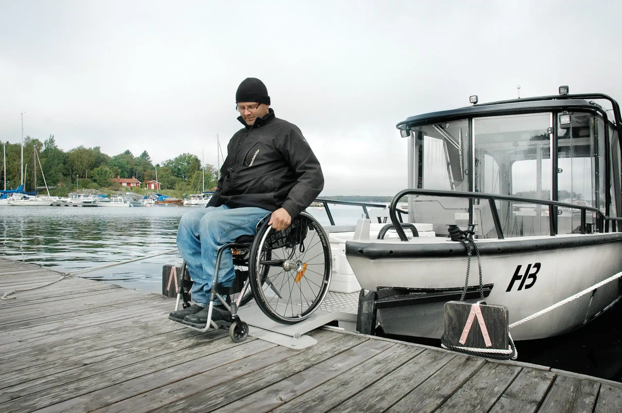 Jonas rullar med sin rullstol nedför rampen från båten Fred
